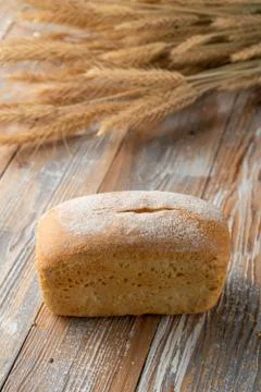 A loaf of white wheat bread on old wooden background Stock Photos