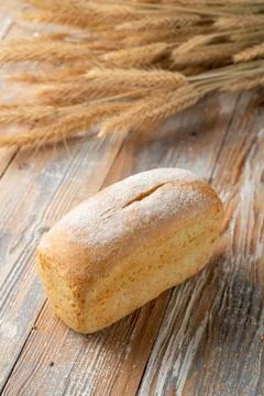 A loaf of white wheat bread on old wooden background Stock Photos