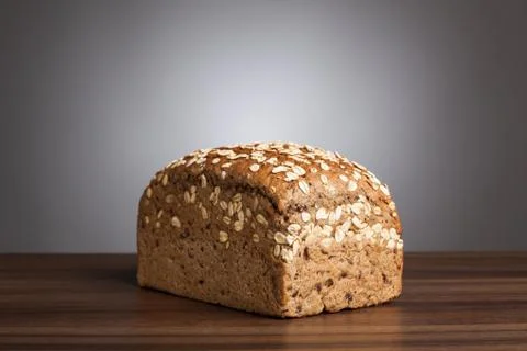 Loaf of wholemeal bread on table Stock Photos