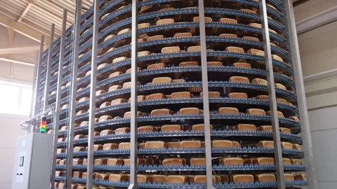 Loafs of bread in a bakery on an automated conveyor belt Stockbeeldmateriaal 154656137
