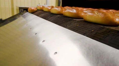 Loafs of bread in a bakery on an automated conveyor belt Vídeos de archivo 195972820