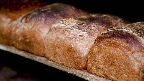 Loafs of bread in a bakery on an automated conveyor belt Vídeo Stock 239983515