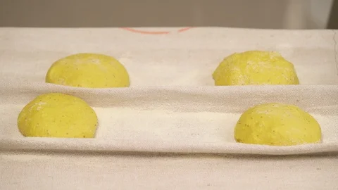 Loafs of bread placed onto a covered with cloth tray. The final fermentation Stock Footage 106255444
