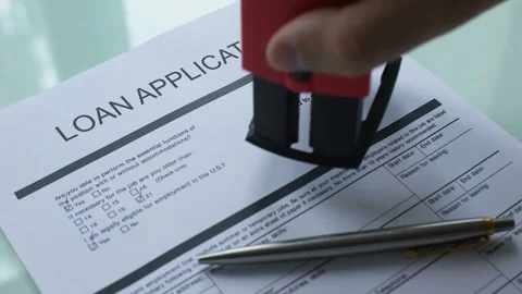 Loan application document rejected, hand stamping seal on official paper closeup Stock Footage 99015798
