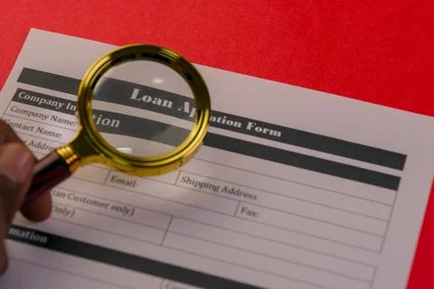 Loan application form under magnifying glass Stock Photos