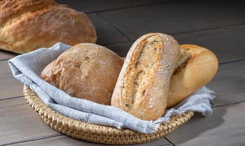 Loaves of bread in a basket on a kitchen table Stock Photos