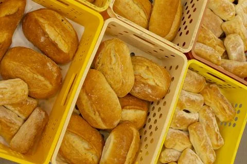 Loaves of bread displayed in plastic baskets at bakeries or grocery stores. Stockfoto's