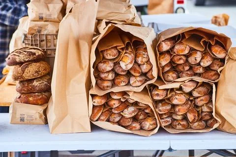 Loaves of bread stuffed into large paper bags on table Foto stock