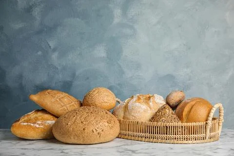 Loaves of different breads on white marble table Foto stock