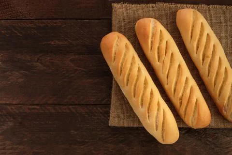 Loaves of white bread on dark texture with copyspace Photos