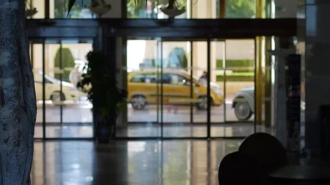 Lobby view through glass with reflections and people passing in 4k slow mot.. Stock Footage 284218785