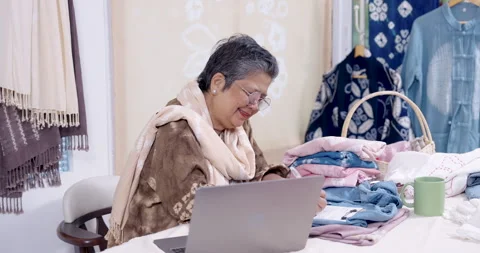 Local artisan e-commerce owner smiles beside laptop, confirms customer order Stock Footage 328337194