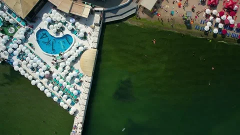 Local beach with swimming pool and many white sun beds Stock Footage 157725573