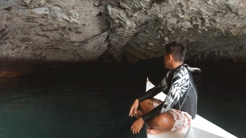Local boat driving into secret cave Stock Footage 103543353