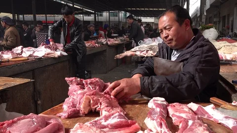 Local butcher cuts fresh pieces of meat market in Shengcun, China Stock Footage