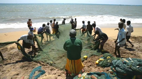 Local fishermen pull net from the ocean on the beach Stock Footage 50634564