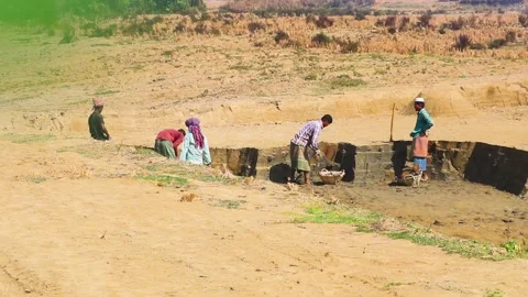 Local group of workers digging clay material for making bricks in rural Stock Footage 235113937