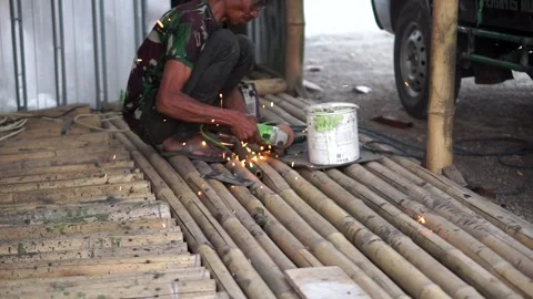 A local laborer cutting metal using a hand grinder, emitting bright sparks Stock Footage 339499984