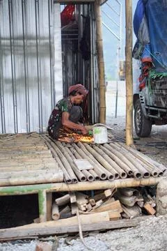 A local laborer cutting metal using a hand grinder, emitting bright sparks Stock Photos