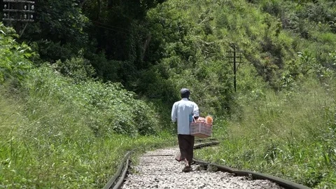 Local Man Walking along train tracks near the village of Ella, Sri Lanka Stock Footage 73424601