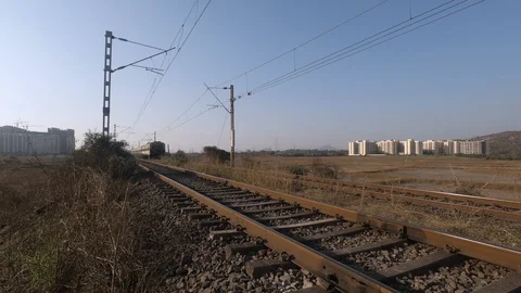 Local passenger train passing through semi-urban area in India Stock Footage 123755604