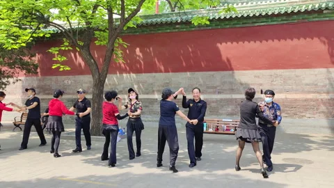Local residents dancing next to a red wall in central Beijing Stock Footage 219458100