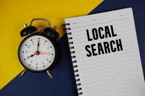Local Search text written on notepad with alarm clock on blue background Stock Photos