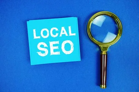 Local SEO text on sticky note with magnifying glass on blue background Stock Photos