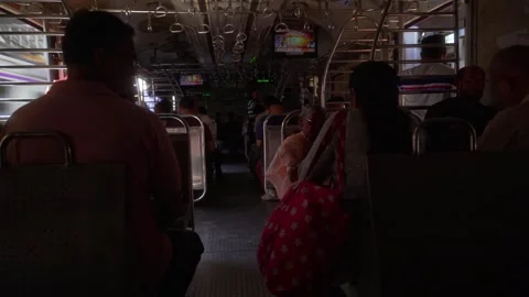 Local suburban train compartment crowded with passengers, with display screen Stock Footage 309025537