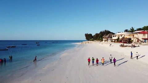 Local teenagers jogging at Nungwi Beach, Zanzibar, Tanzania Stock Footage