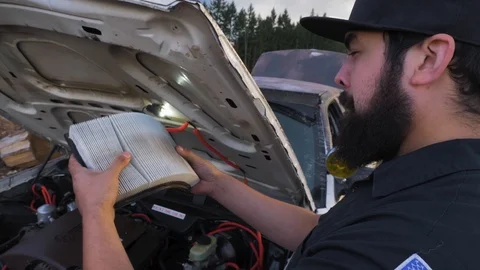Local town mechanic checking air filter closely on old car Vídeo Stock 107612134