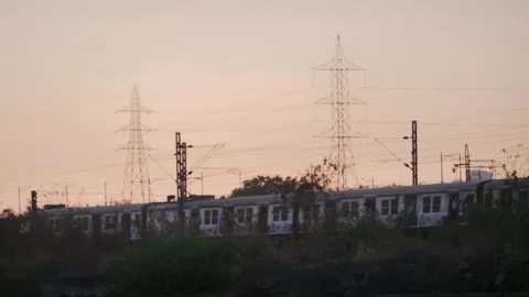 Local train passing silhouetted against the vibrant evening sky, Mumbai, India Vídeo Stock 337092984
