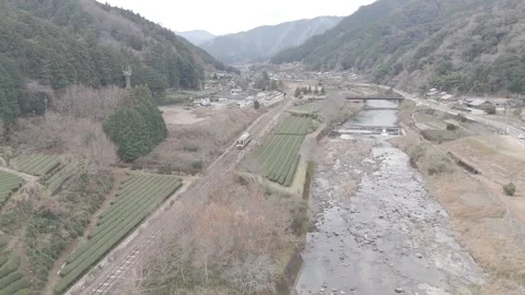 Local Train Passing Through Rural Japanese Countryside – 4K Aerial Stock Footage 325408443