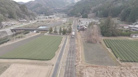 Local Train Passing Through Rural Tea Fields – Japan 4K Aerial Stock Footage 325408444