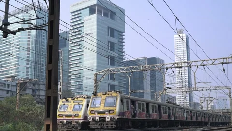 Local trains passing in front of the modern commercial skyscrapers in Mumbai Stock Footage 331923356