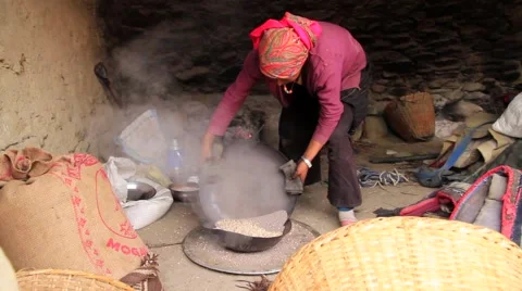 Local woman using a sieve to separate sand from the food grain, Mustang, Nepal Stock Footage 62923999