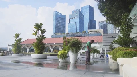 Local worker power washing the sidewalks in front of a luxury hotel. Video stock 82225058