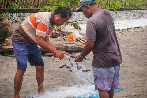 Local Workers with Large Mesh on Beach Foto stock