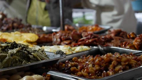 Locals quickly pack warm rice, meat, and vegetables into foam boxes, capturing Stock Footage 312260097