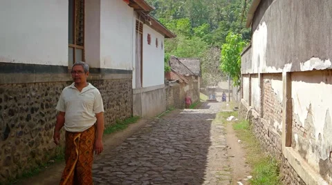 Locals walking along a typical, old street in a Balinese village Vidéo 67085711