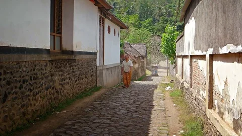 Locals walking along a typical, old street in a Balinese village Video stock 74622344