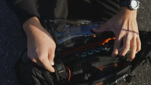 Location sound operator adjusting portable audio mixer, closeup on hands Stock Footage 85369979