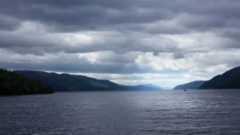 Loch ness landscape under moody cloudy sky with distant sailboat Stock Footage 344544963