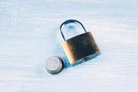 Lock and coins on the table Stock Photos