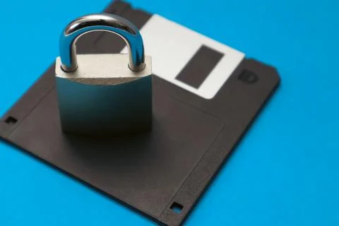 The lock is on the black retro 3.5" floppy diskette. Cyber security and dat.. Stock Photos