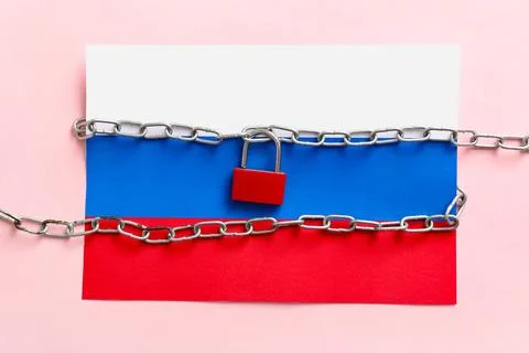 Lock with chains and Russian flag on pink background. Sanctions concept Stock Photos