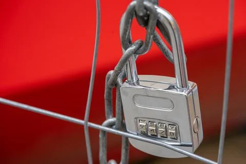 Lock with code number and chain on a metal fence Фото