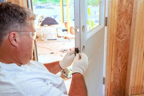 Lock doorknob installation by locksmith using a screwdriver Stock Photos