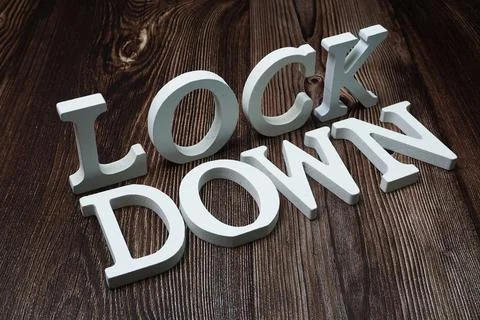 Lock Down alphabet letters on wooden background Stock Photos