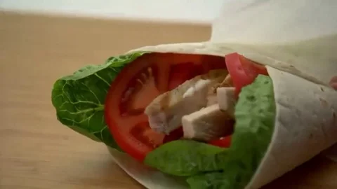 Lock down of chicken wrap being wrapped in paper Stock Footage 98247766